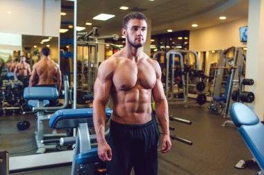 Very power athletic guy bodybuilder. Posing in front of a mirror