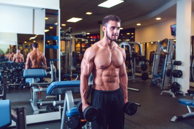 Çok güç atletik adam vücut geliştirmeci, egzersiz dumbbells ile yürütmek