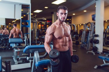 Çok güç atletik adam vücut geliştirmeci, egzersiz dumbbells ile yürütmek