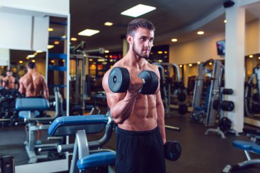 Çok güç atletik adam vücut geliştirmeci, egzersiz dumbbells ile yürütmek