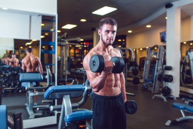 Çok güç atletik adam vücut geliştirmeci, egzersiz dumbbells ile yürütmek