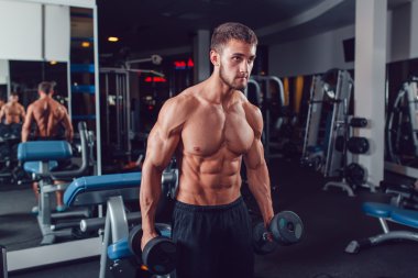 Çok güç atletik adam vücut geliştirmeci, egzersiz dumbbells ile yürütmek