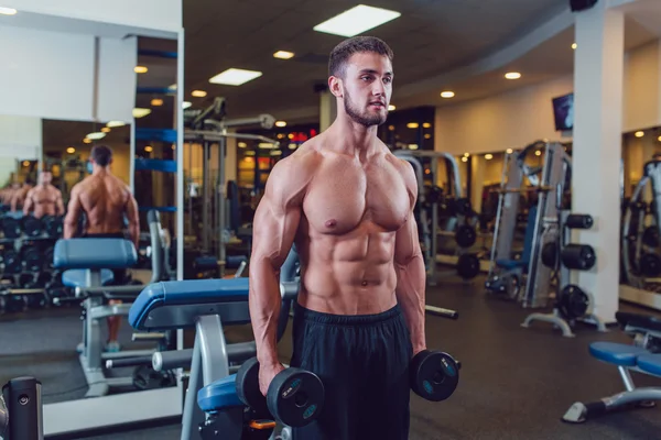 Zeer macht atletische man bodybuilder, uitvoeren van de oefening met halters — Stockfoto