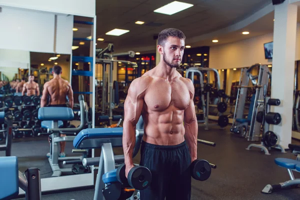 Çok güç atletik adam vücut geliştirmeci, egzersiz dumbbells ile yürütmek — Stok fotoğraf