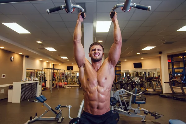 Zeer macht atletische man bodybuilder, uitvoeren van de oefening met horizontale balk — Stockfoto