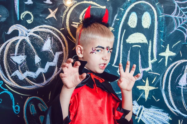 Menino em um traje de Drácula posando no fundo da inscrição Halloween — Fotografia de Stock