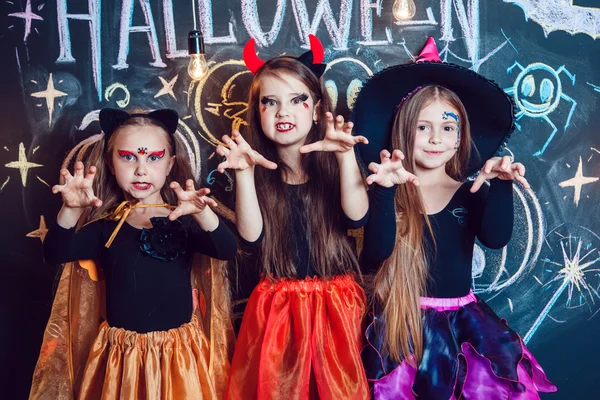 Mädchen in Halloween-Kostümen zeigen Emotionen wie Hexen. Halloween-Party mit Kindern in der Gruppe. — Stockfoto