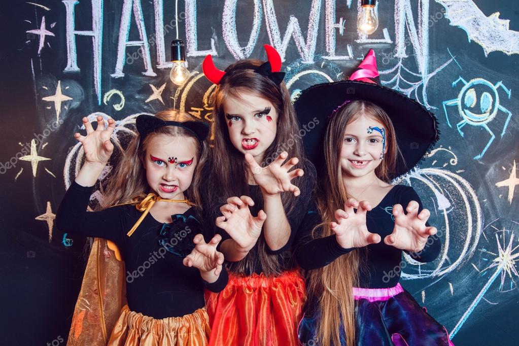 Girls, dressed up in Halloween costumes, show emotions of witches