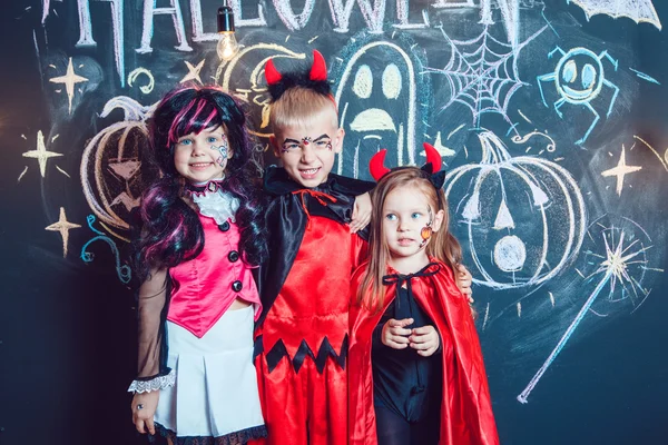 Meninas, vestidas com trajes de Halloween, mostram emoções de bruxas. Festa de Halloween com crianças de grupo . — Fotografia de Stock