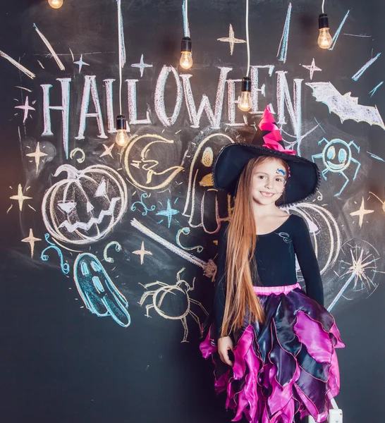 Ragazza vestita con costumi di Halloween. Posa sullo sfondo dell'iscrizione Halloween . — Foto Stock