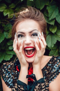 Yaprakların bir arka plan üzerine bir manikür ile güzel kız