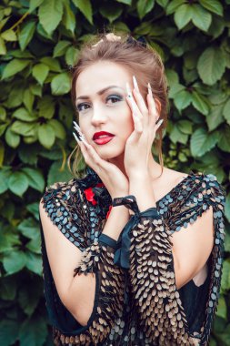 Yaprakların bir arka plan üzerine bir manikür ile güzel kız