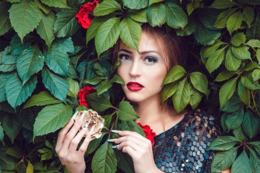 Yaprakların bir arka plan üzerine bir manikür ile güzel kız