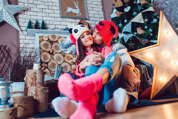 A loving couple in funny hats posing in Christmas decorations — Stock Photo, Image