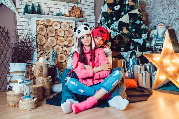 A loving couple in funny hats posing in Christmas decorations — Stock Photo, Image