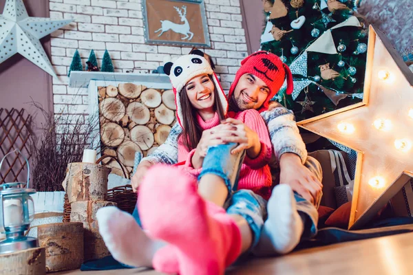 Um casal amoroso em chapéus engraçados posando em decorações de Natal — Fotografia de Stock