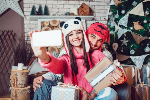 Casal apaixonado em decorações de Natal fazer a selfie — Fotografia de Stock