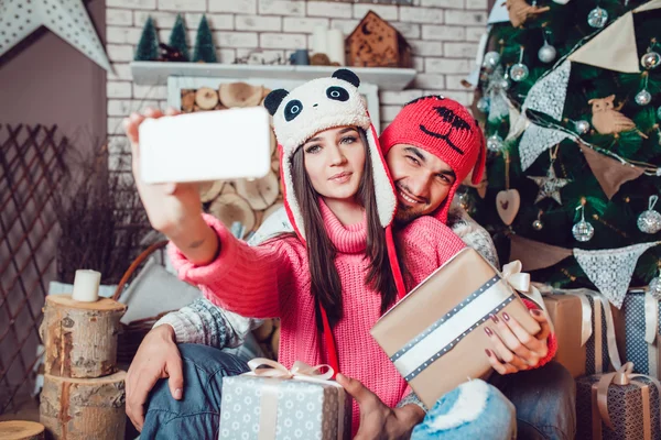 Casal apaixonado em decorações de Natal fazer a selfie — Fotografia de Stock