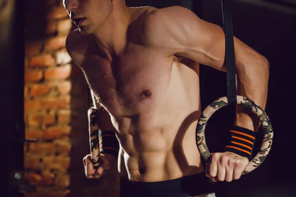 Athlete makes exercise on rings — Stock Photo, Image