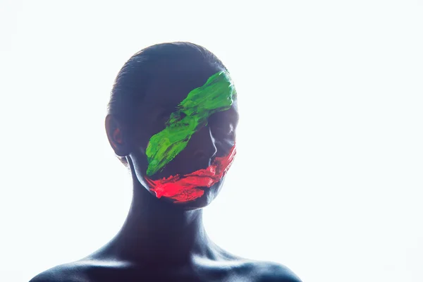 Girl with a black paint on the face. Green and red stripes. — Stock Photo, Image