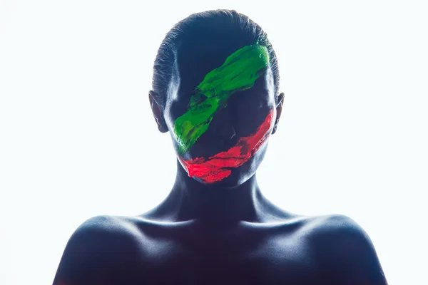 Κορίτσι με ένα μαύρο χρώμα στο πρόσωπο. Πράσινες και κόκκινες λωρίδες. — Φωτογραφία Αρχείου