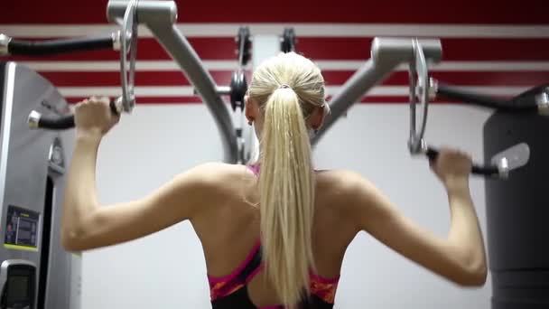 Mulher desportiva a fazer exercícios no simulador. Músculos abdominais. Leggings brilhantes . — Vídeo de Stock