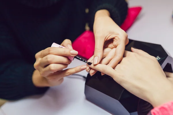 Manicure. Salon van de schoonheid. Close-up. Toepassing van de zwarte nagellak. — Stockfoto