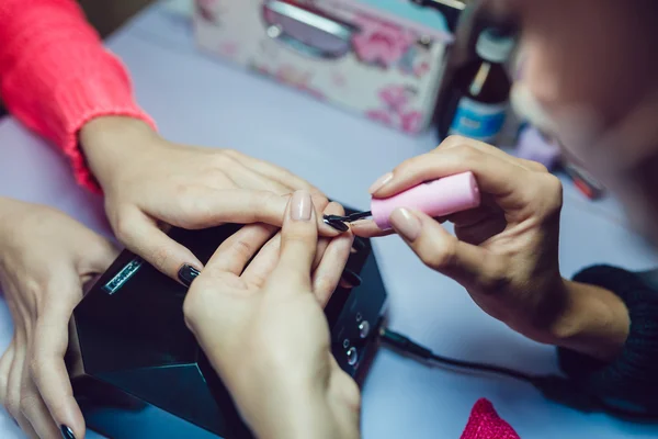 Manicure. Salon van de schoonheid. Close-up. Toepassing van de zwarte nagellak. — Stockfoto