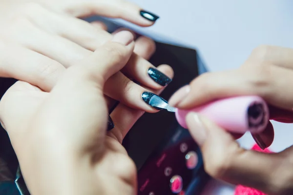 Manicura. Salón de belleza. Primer plano. Aplicar esmalte de uñas negro . — Foto de Stock