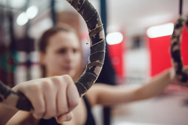 Esporte menina está se preparando para um exercício sobre os anéis — Fotografia de Stock