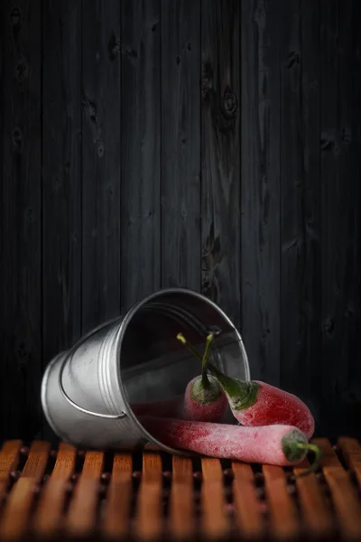 Üç donmuş kırmızı gazete ve düşmüş kova.