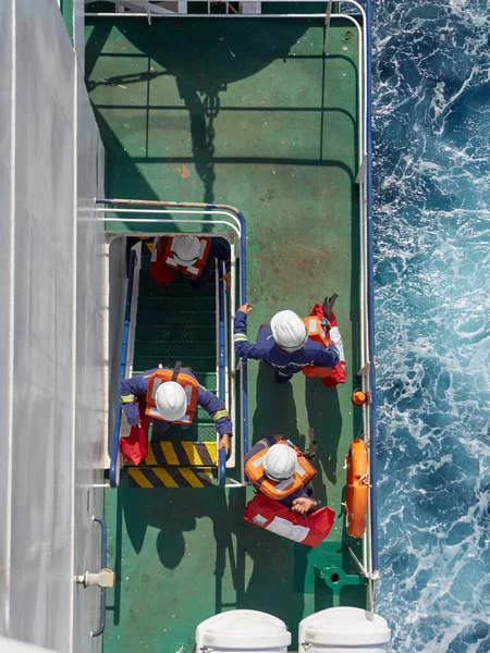 Exercícios de navios abandonados em mar aberto no navio. Quatro pessoas se preparando para deixar o navio. Imagens Royalty-Free