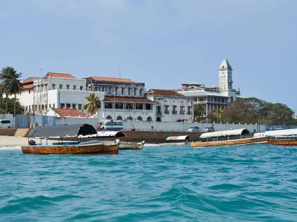 Gün boyunca deniz kıyısından Ston Town 'a manzara ve önünde balıkçı tekneleri. Taş Şehir, Zanzibar.