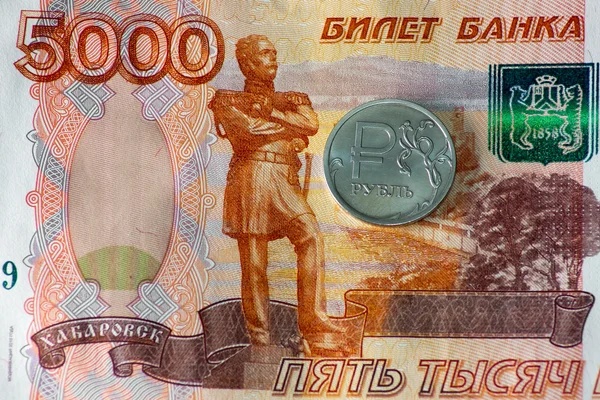 Une pièce en rouble et cinq mille billets — Photo