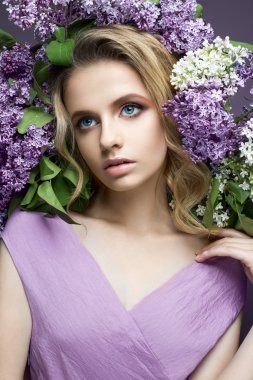 Güzel kız mor elbise ve leylak bir buket. Bahar görüntüde modelidir.