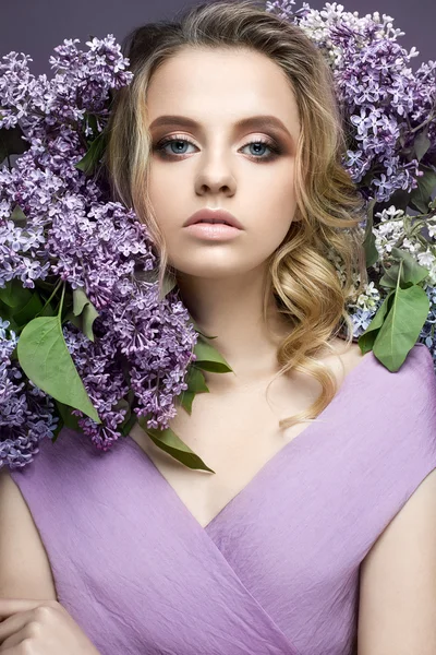 Belle fille en robe violette et un bouquet de lilas. Le modèle est dans une image de printemps . — Photo