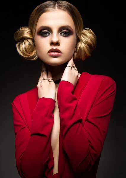 Mooi meisje in een rode jurk met een diepe decollete en zwarte ringen op zijn vingers. Het model met lichte make-up. — Stockfoto
