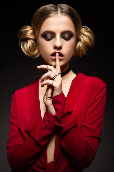 Beautiful girl in a red dress with a deep neckline and black rings on his fingers. The model with bright makeup. — Stock Photo, Image