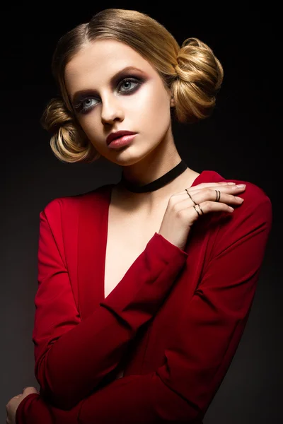 Beautiful girl in a red dress with a deep neckline and black rings on his fingers. The model with bright makeup. — Stock Photo, Image