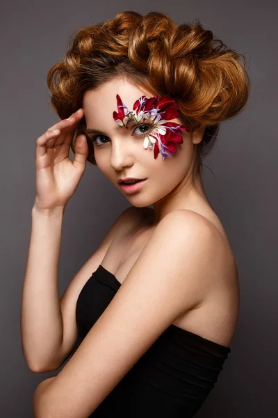 Belle fille avec maquillage créatif avec des appliques florales. Le modèle dans le style romantique avec des pétales de fleurs autour de ses yeux . — Photo