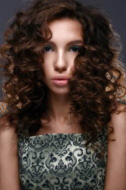 Bukleler ve göz kapaklarının üzerinde yeşil glitter ile güzel kız. Güzel makyaj ve kıvırcık saç modeli kadınla