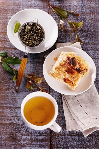 Xícara de chá verde e bolo sobre fundo de madeira rústica — Fotografia de Stock