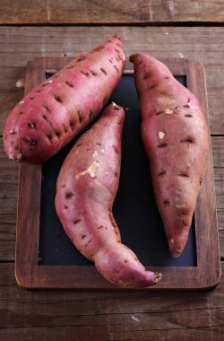 Bir kara tahta üzerinde kırmızı tatlı patates 