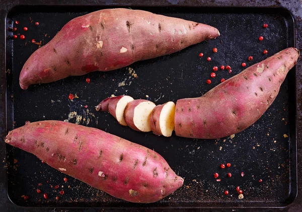 Rode zoete aardappel over rustieke metalen lade Stockfoto