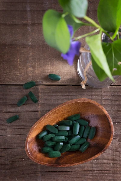 Spirulina pills on a rustic table — Stock Photo, Image