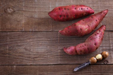 Rustik ahşap arka plan üzerinde kırmızı tatlı patates