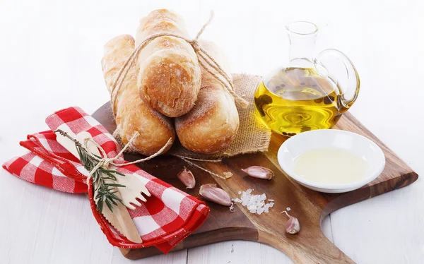 Freshly baked bread rolls with oil and spices — Stock Photo, Image