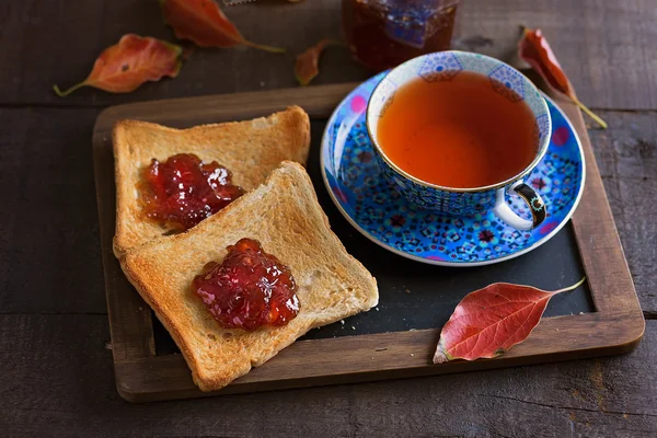 Xícara de chá e torradas sobre fundo de madeira rústico — Fotografia de Stock