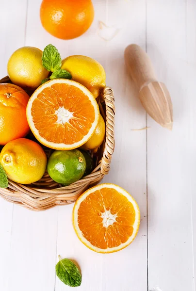 Oranges, citrons et citrons verts sur fond de bois blanc — Photo