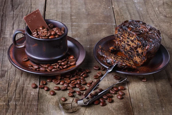 Roasted coffee beans and fruit cake over rustic wooden backgroun — Stock Photo, Image